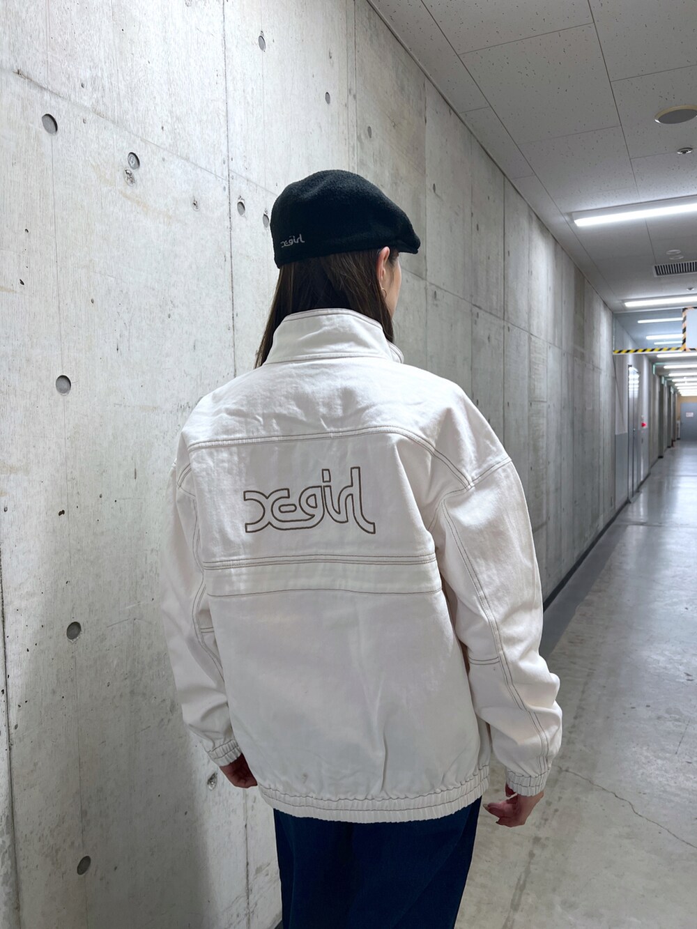 ホワイト系のブルゾン、ピンク系のTシャツ/カットソー、ブルー系のデニムパンツを着用したレディースの冬コーディネートの5枚目の写真
