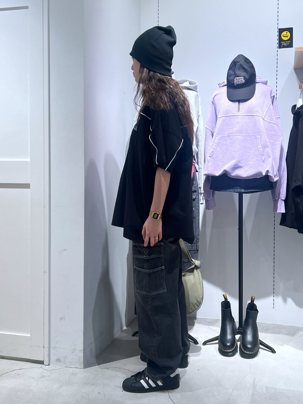 ブラック系のワンピース、ブラック系のカーゴパンツ、グリーン系のショルダーバッグを着用したレディースの春コーディネートの2枚目の写真