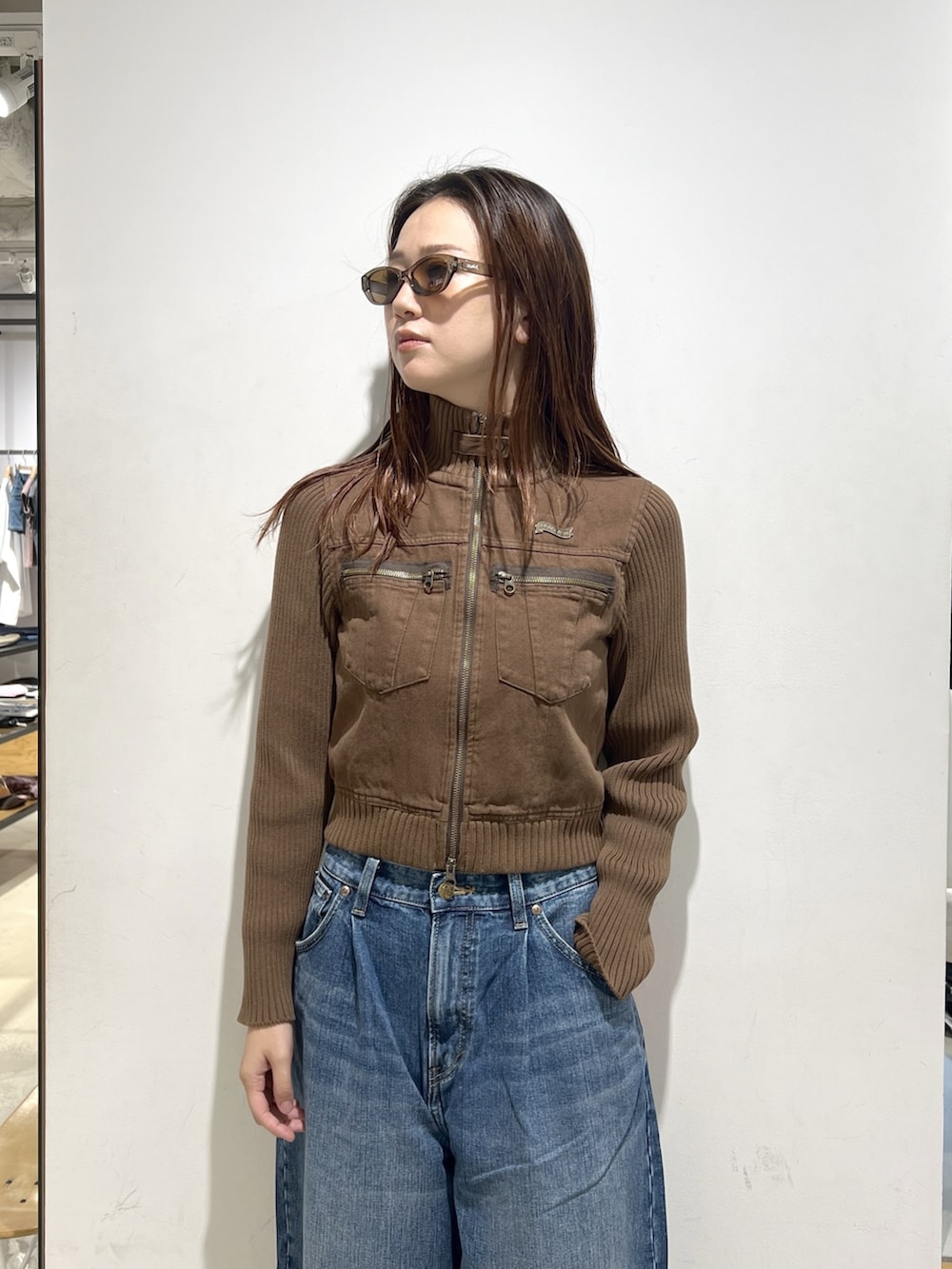 ブルー系のデニムパンツ、ブラウン系のブルゾンを着用したレディースの夏コーディネートの4枚目の写真