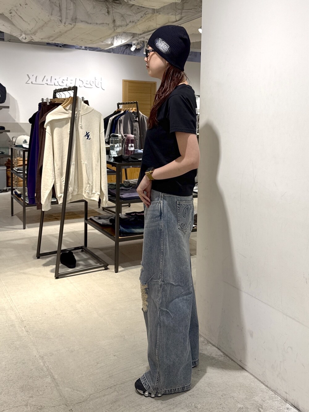 ブラック系のTシャツ/カットソー、ブルー系のデニムパンツ、ブラック系のニットキャップ/ビーニーを着用したレディースの夏コーディネートの2枚目の写真