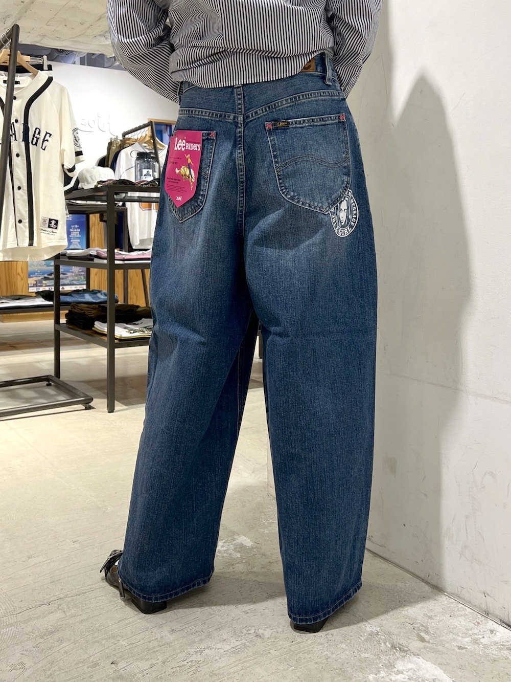 ブルー系のデニムパンツ、ブラウン系のブルゾンを着用したレディースの夏コーディネートの5枚目の写真
