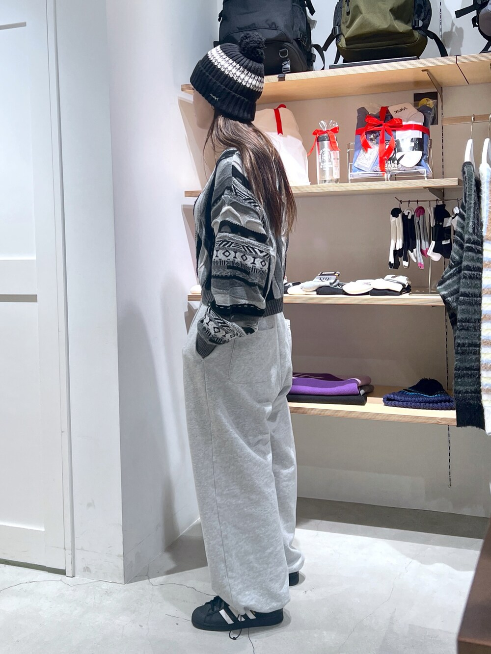 ブラック系のニット/セーター、グレー系のスウェットパンツ、ブラック系のニットキャップ/ビーニーを着用したレディースの冬コーディネートの2枚目の写真
