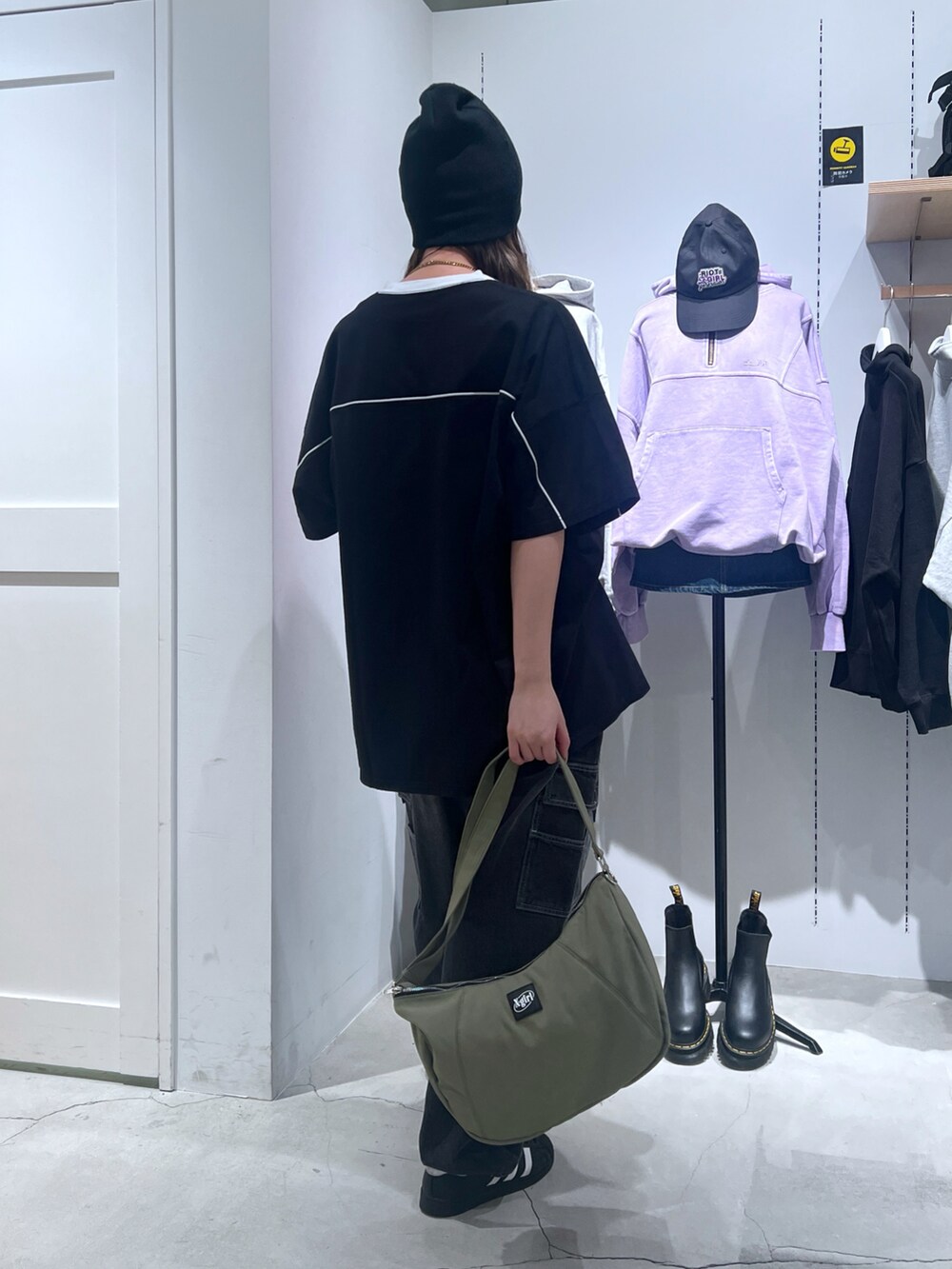 ブラック系のワンピース、ブラック系のカーゴパンツ、グリーン系のショルダーバッグを着用したレディースの春コーディネートの3枚目の写真