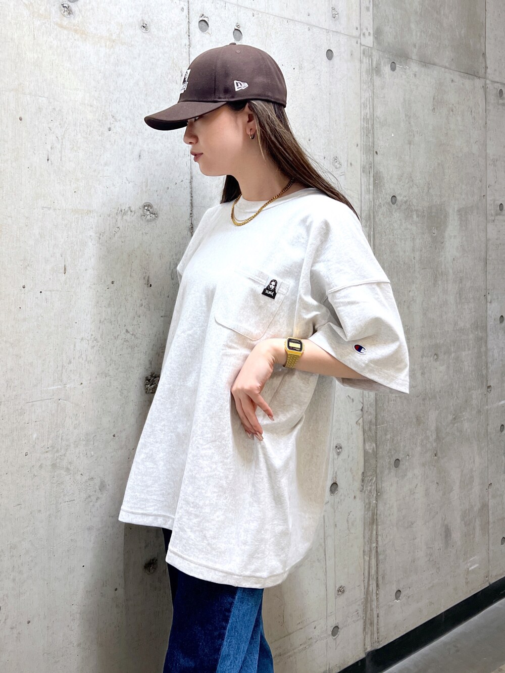 ブラック系のショルダーバッグ、グレー系のTシャツ/カットソー、ブルー系のデニムパンツを着用したレディースの春コーディネートの5枚目の写真