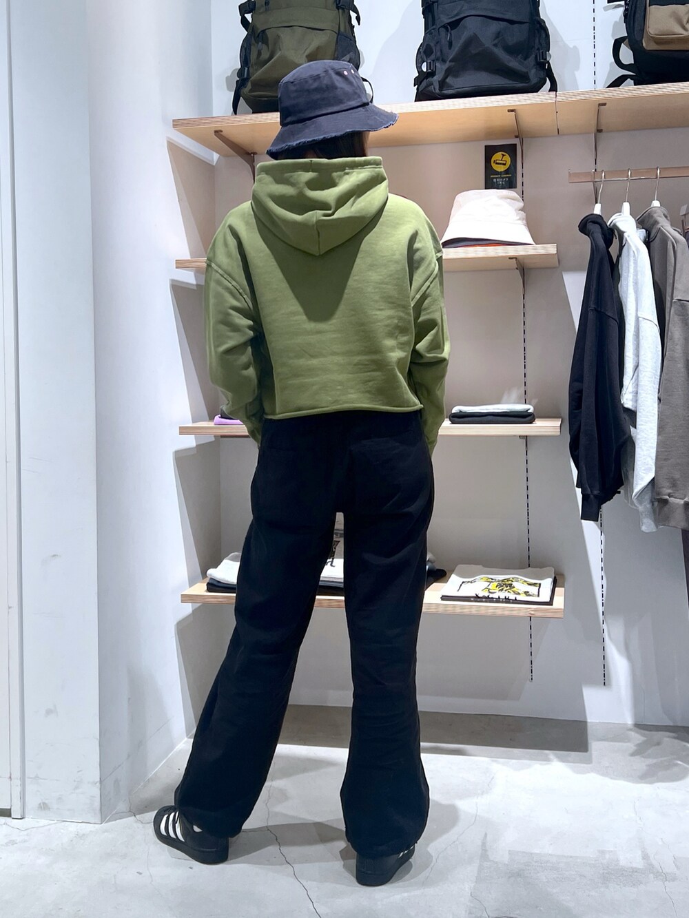 グリーン系のパーカー、ブラック系のその他パンツを着用したレディースの春コーディネートの2枚目の写真