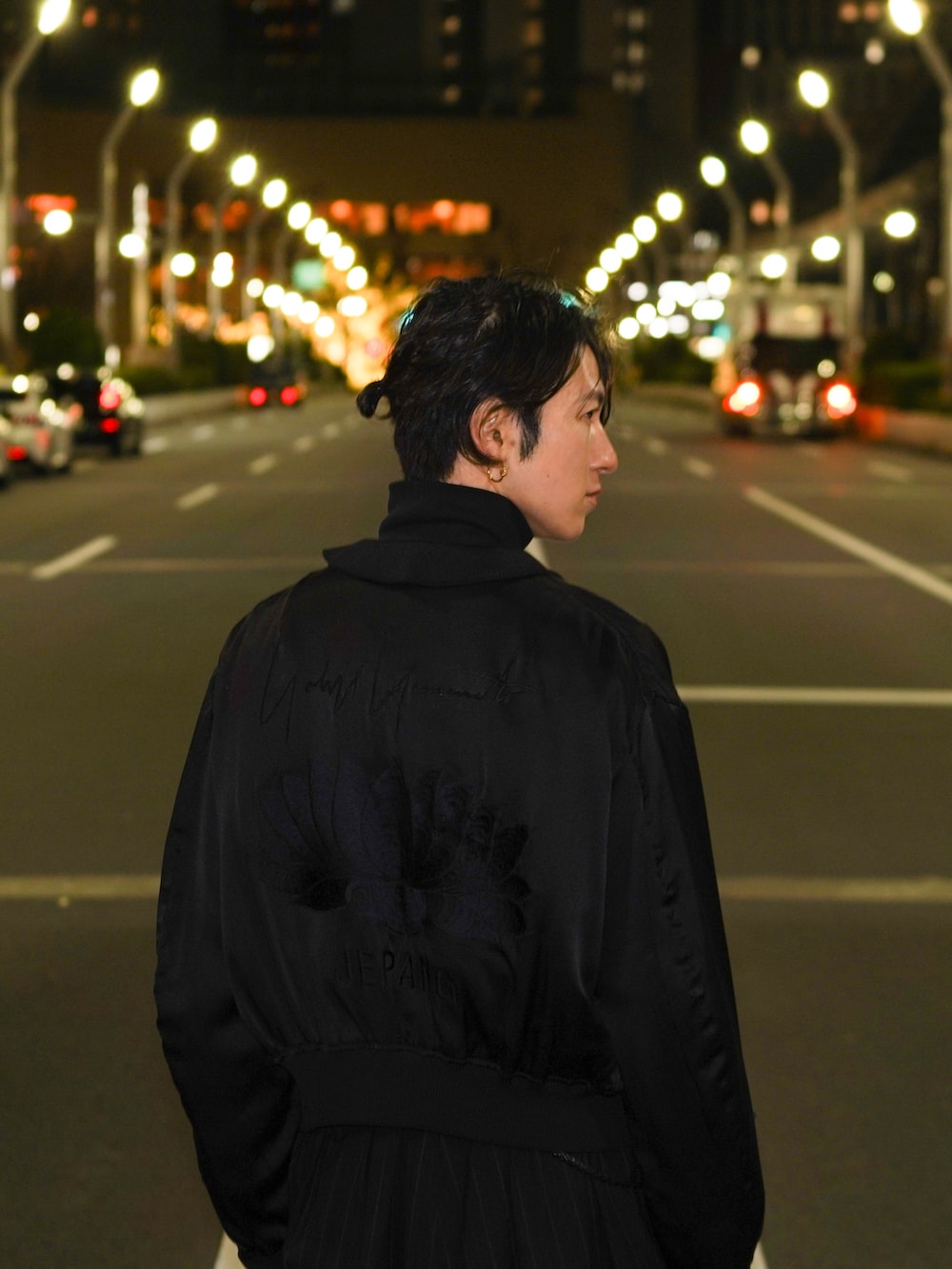 ブラック系のスニーカー、ブラック系のスカジャン、ブラック系のTシャツ/カットソーを着用したメンズの冬コーディネートの4枚目の写真