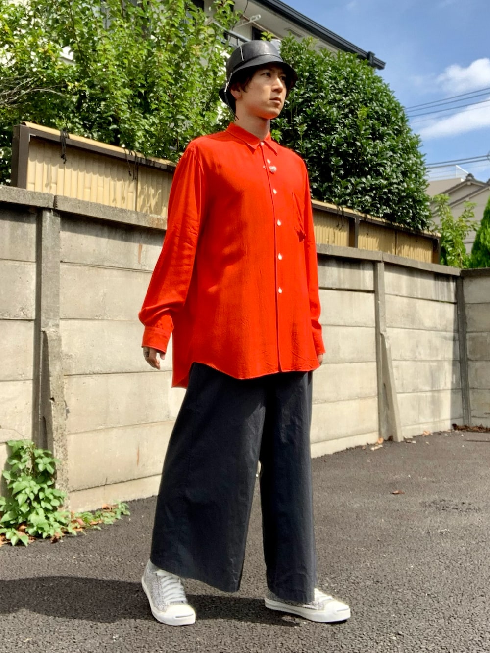 レッド系のシャツ/ブラウス、グレー系のスラックス、ホワイト系のスニーカーを着用したメンズの秋コーディネートの2枚目の写真