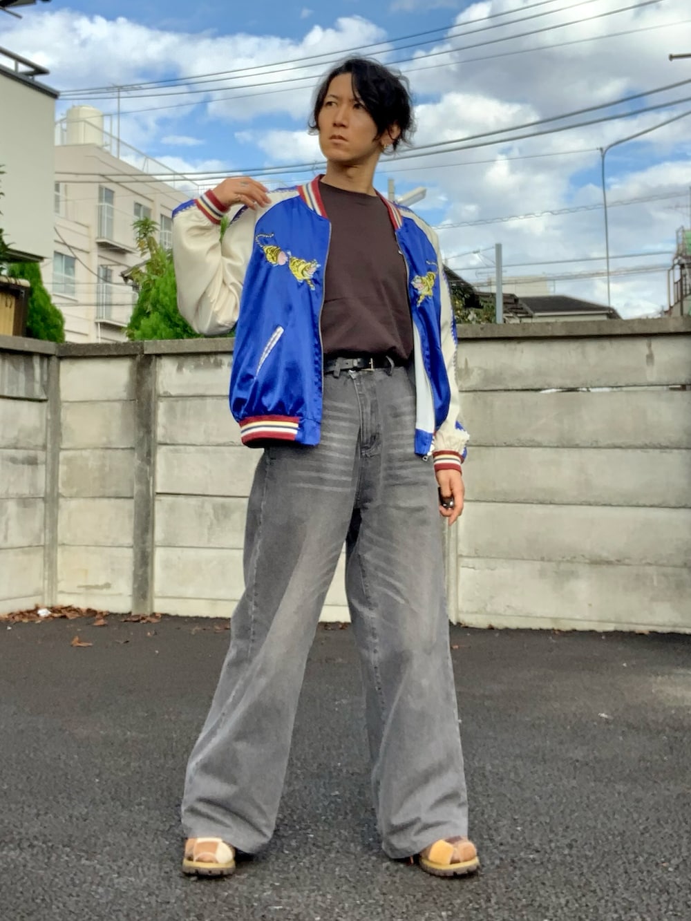 グレー系のデニムパンツ、ブルー系のスカジャン、ブラウン系のTシャツ/カットソーを着用したメンズの秋コーディネートの5枚目の写真