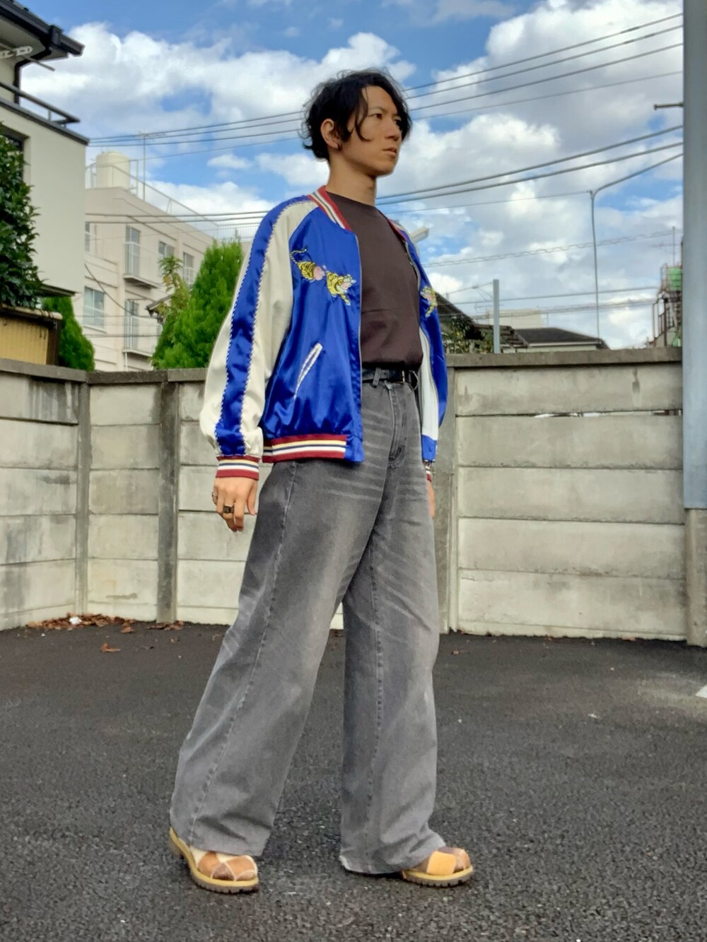 グレー系のデニムパンツ、ブルー系のスカジャン、ブラウン系のTシャツ/カットソーを着用したメンズの秋コーディネートの2枚目の写真