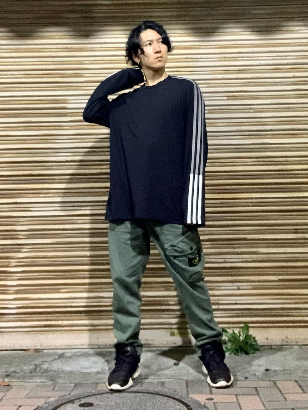 ブラック系のTシャツ/カットソー、グリーン系のカーゴパンツ、ブラック系のスニーカーを着用したメンズの秋コーディネートの5枚目の写真