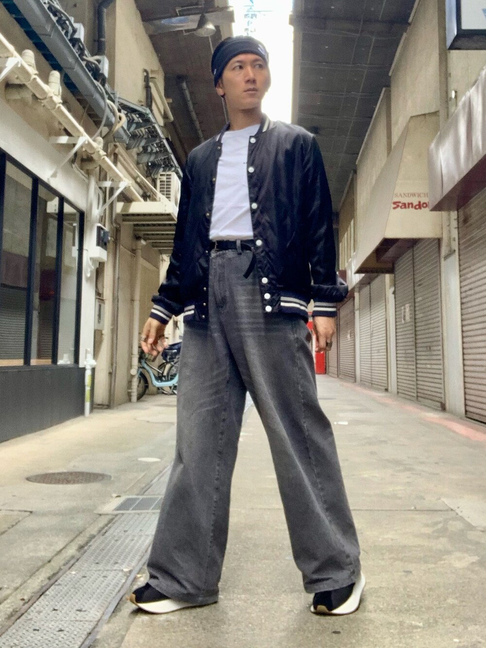 ブラック系のスタジャン、ホワイト系のTシャツ/カットソー、グレー系のデニムパンツを着用したメンズの秋コーディネートの3枚目の写真