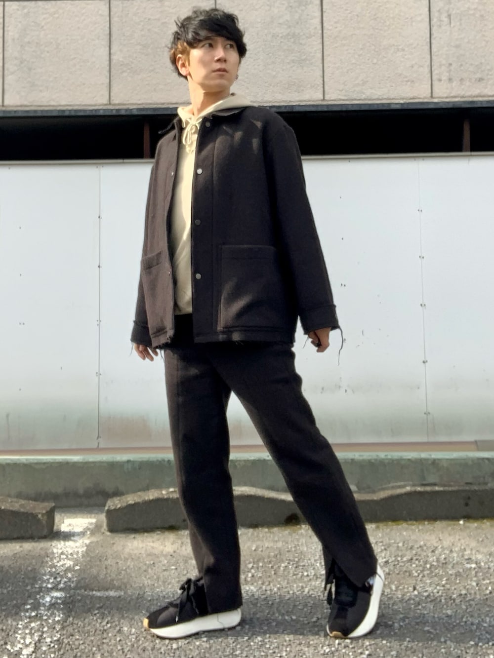 ベージュ系のパーカー、ブラウン系のブルゾン、ブラウン系のスラックスを着用したメンズの秋コーディネートの3枚目の写真