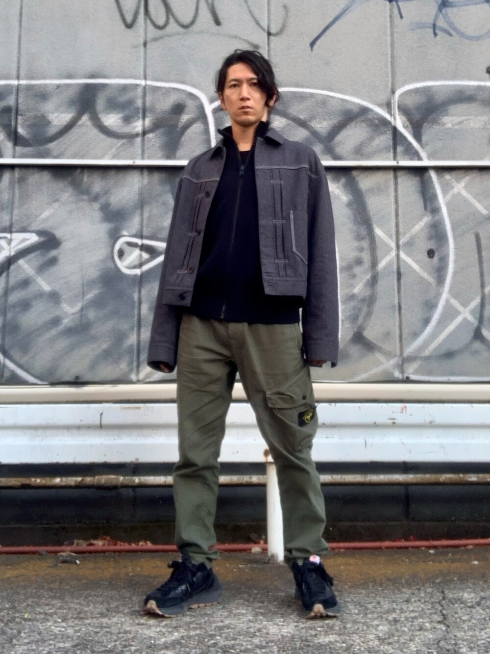 グリーン系のカーゴパンツ、グレー系のデニムジャケット、ブラック系のニット/セーターを着用したメンズの冬コーディネートの5枚目の写真