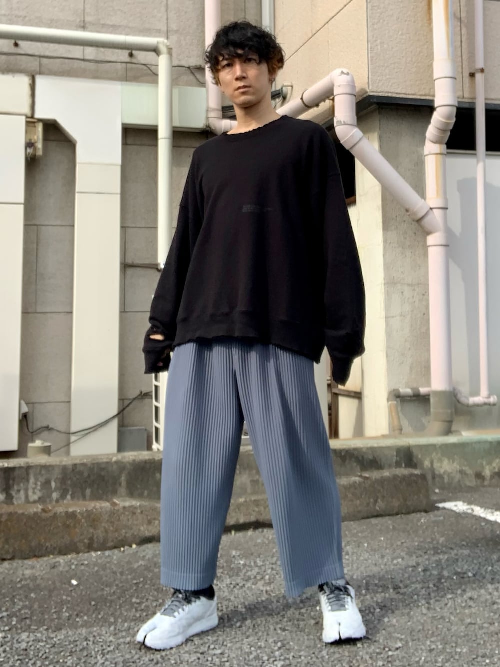 ブラック系のスウェット、ブルー系のパンツ、ホワイト系のスニーカーを着用したメンズの秋コーディネートの3枚目の写真