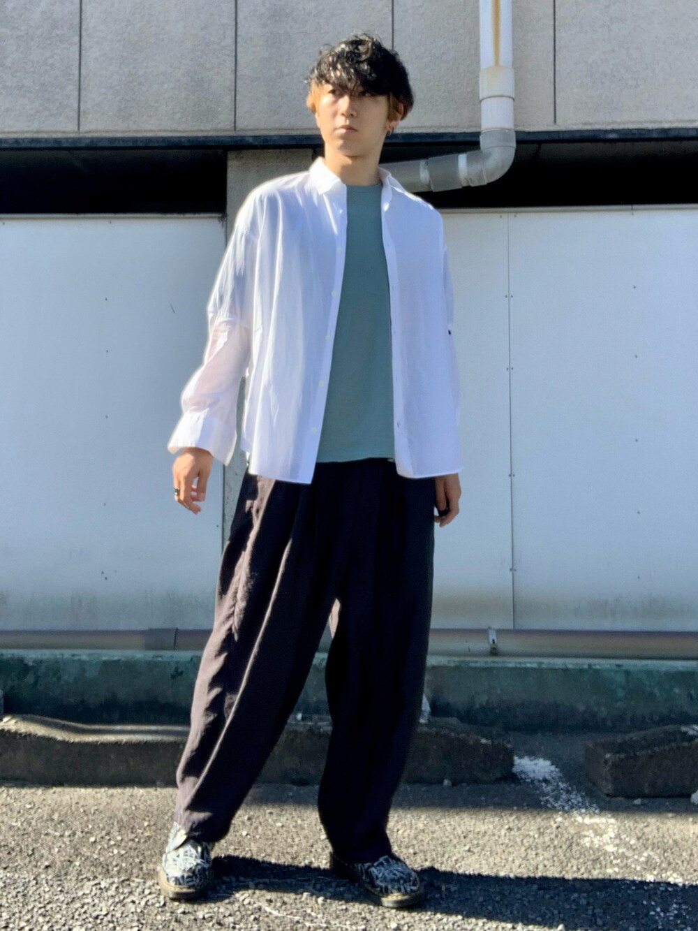 ホワイト系のシャツ/ブラウス、ブルー系のTシャツ/カットソー、ブラック系のスラックスを着用したメンズの秋コーディネートの2枚目の写真