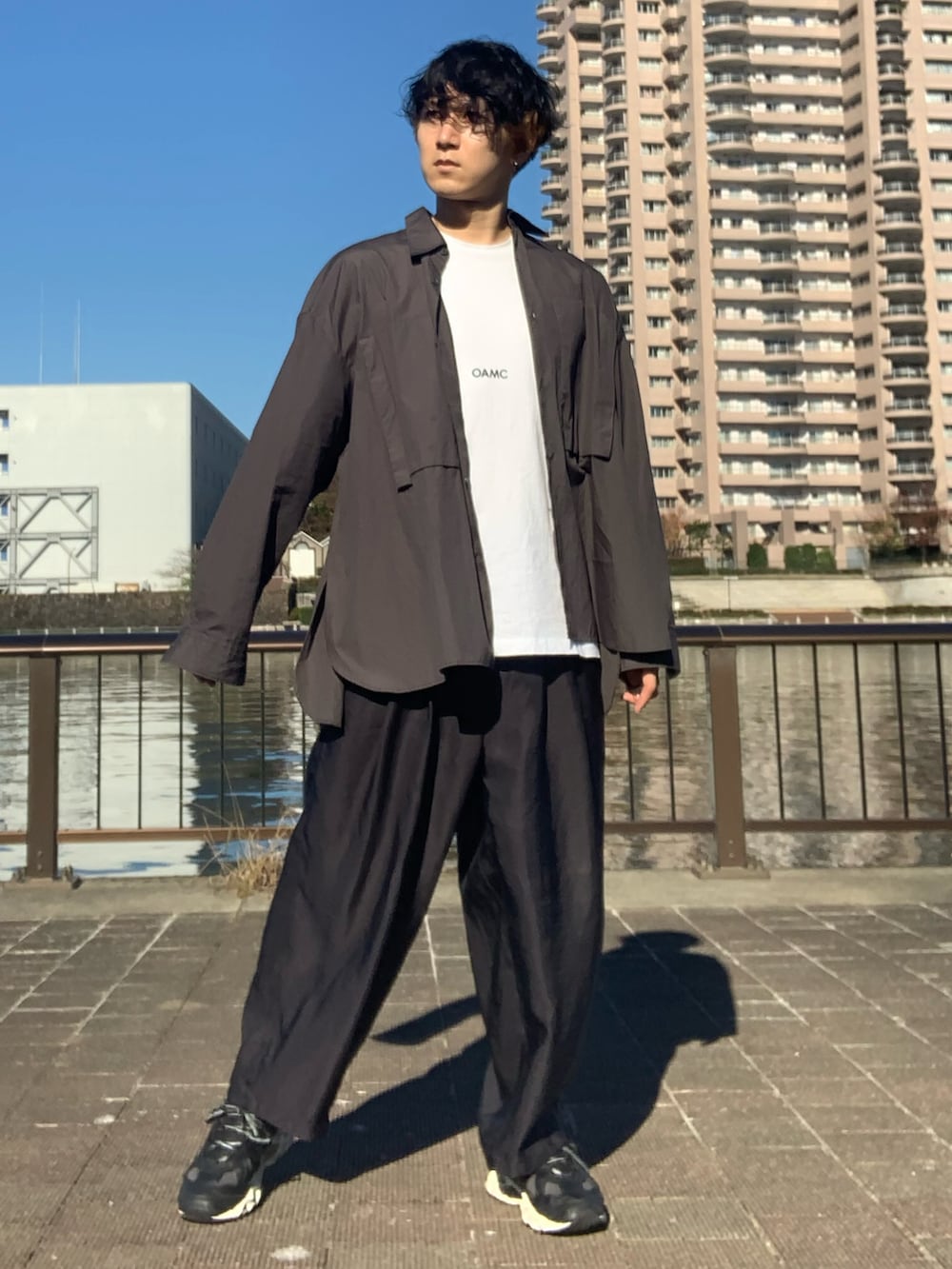 グレー系のシャツ/ブラウス、ホワイト系のTシャツ/カットソー、ブラック系のスラックスを着用したメンズの秋コーディネートの4枚目の写真