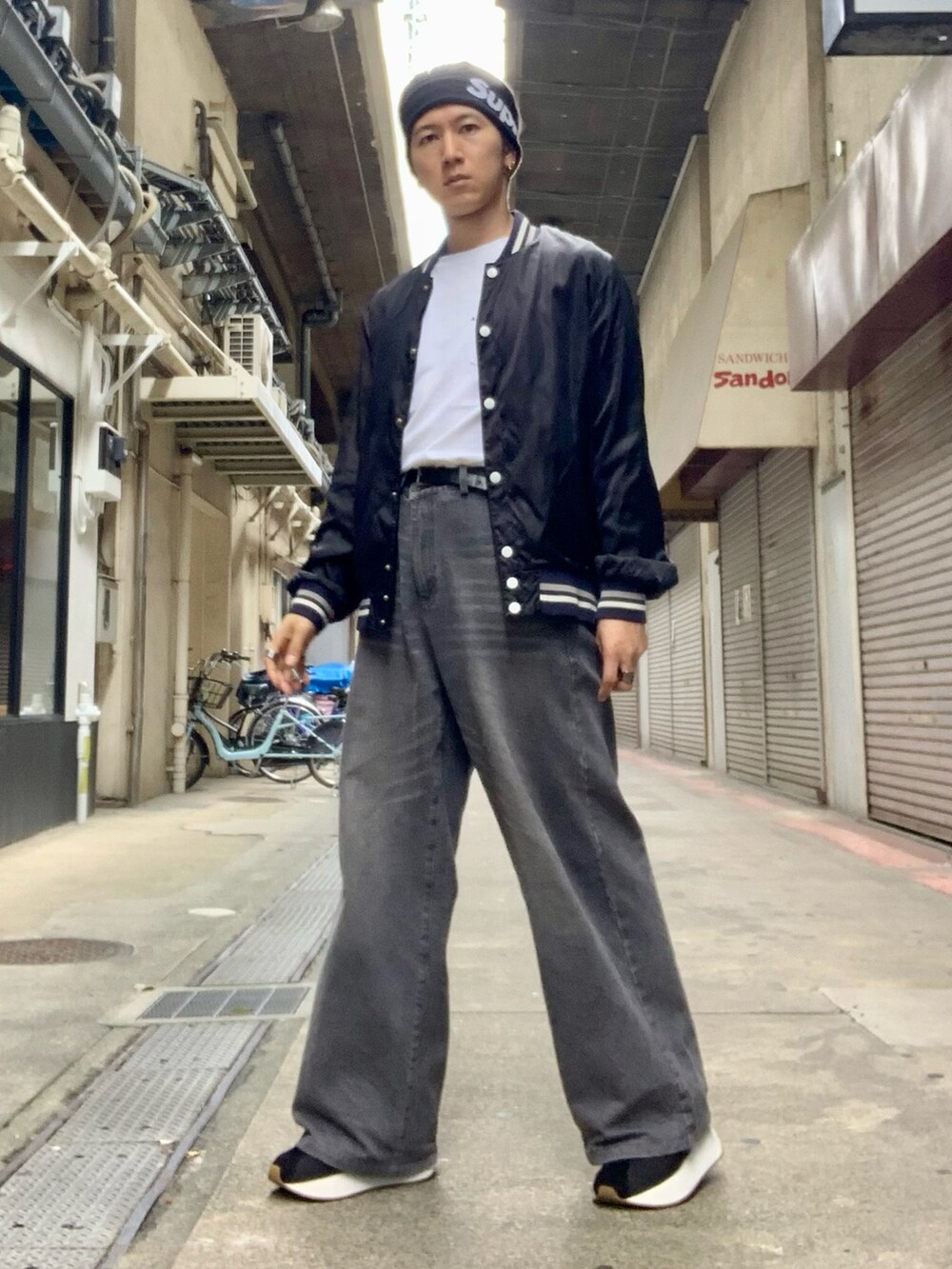 ブラック系のスタジャン、ホワイト系のTシャツ/カットソー、グレー系のデニムパンツを着用したメンズの秋コーディネートの4枚目の写真