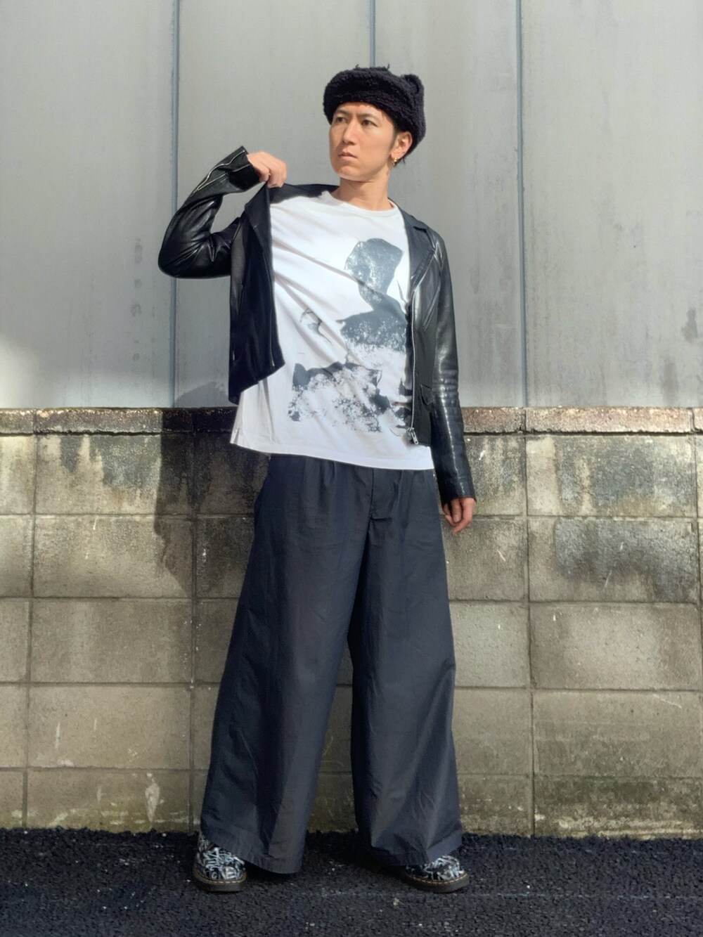 グレー系のスラックス、ホワイト系のTシャツ/カットソー、ブラック系のブーツを着用したメンズの秋コーディネートの2枚目の写真