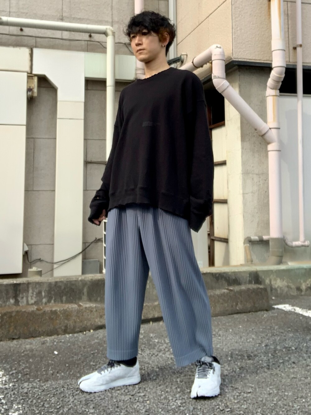 ブラック系のスウェット、ブルー系のパンツ、ホワイト系のスニーカーを着用したメンズの秋コーディネートの5枚目の写真