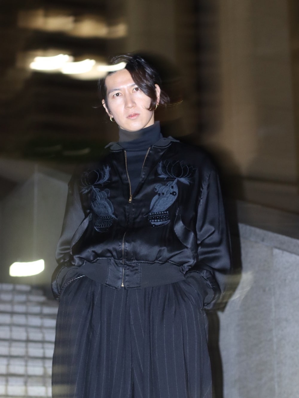 ブラック系のスニーカー、ブラック系のスカジャン、ブラック系のTシャツ/カットソーを着用したメンズの冬コーディネートの5枚目の写真