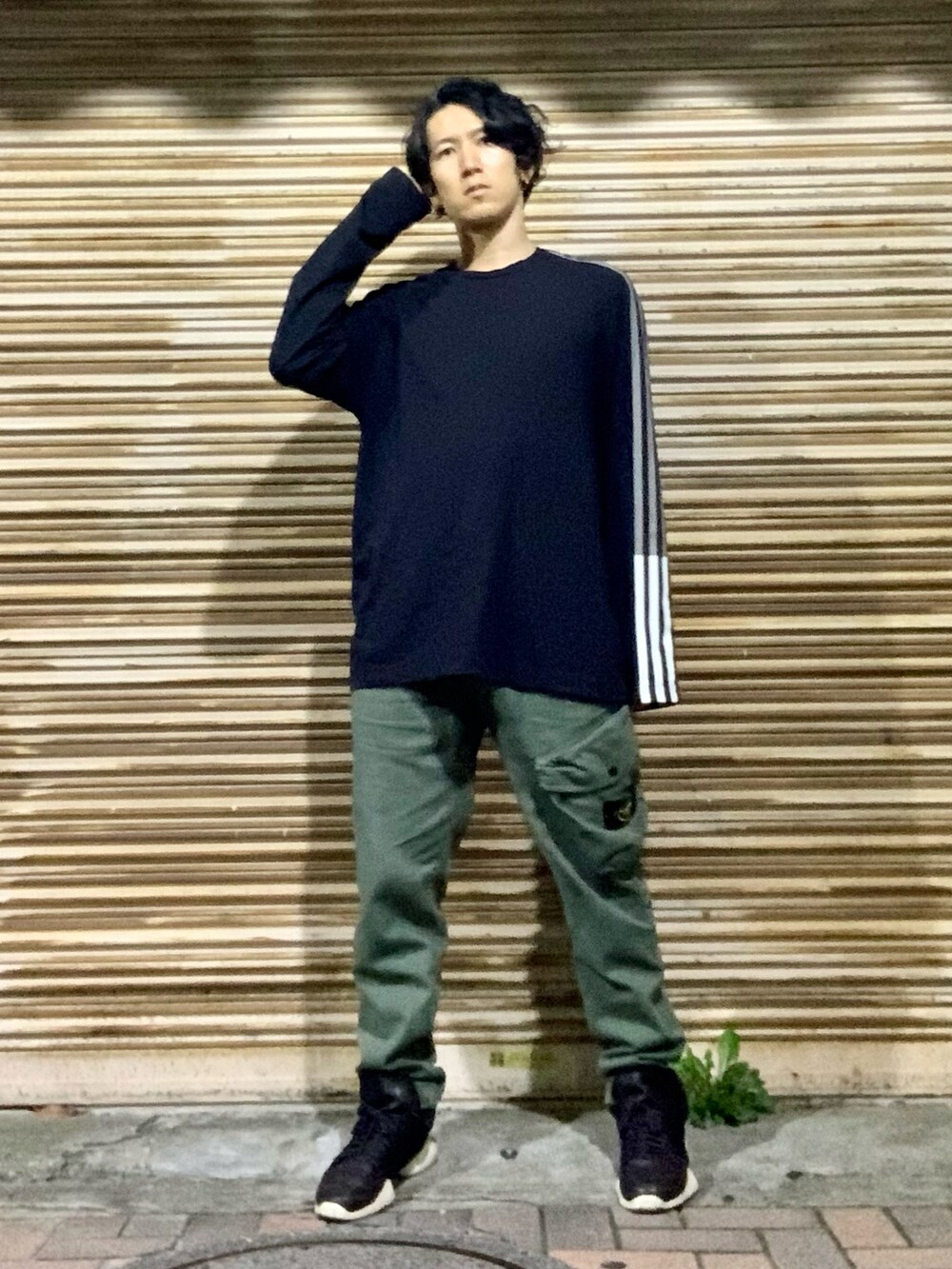 ブラック系のTシャツ/カットソー、グリーン系のカーゴパンツ、ブラック系のスニーカーを着用したメンズの秋コーディネートの3枚目の写真