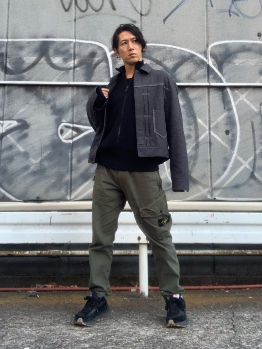 グリーン系のカーゴパンツ、グレー系のデニムジャケット、ブラック系のニット/セーターを着用したメンズの冬コーディネートの2枚目の写真