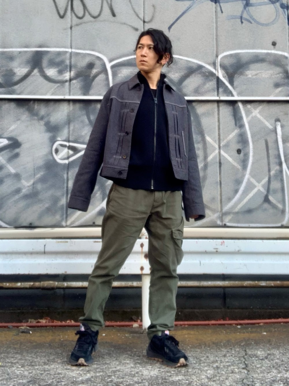 グリーン系のカーゴパンツ、グレー系のデニムジャケット、ブラック系のニット/セーターを着用したメンズの冬コーディネートの4枚目の写真