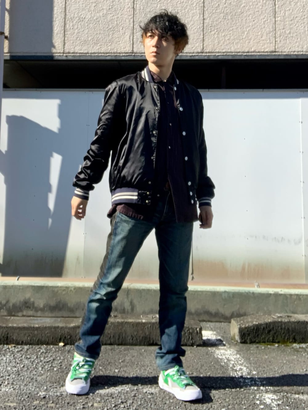 ブラック系のスタジャン、ブラウン系のシャツ/ブラウス、ブルー系のデニムパンツを着用したメンズの秋コーディネートの3枚目の写真