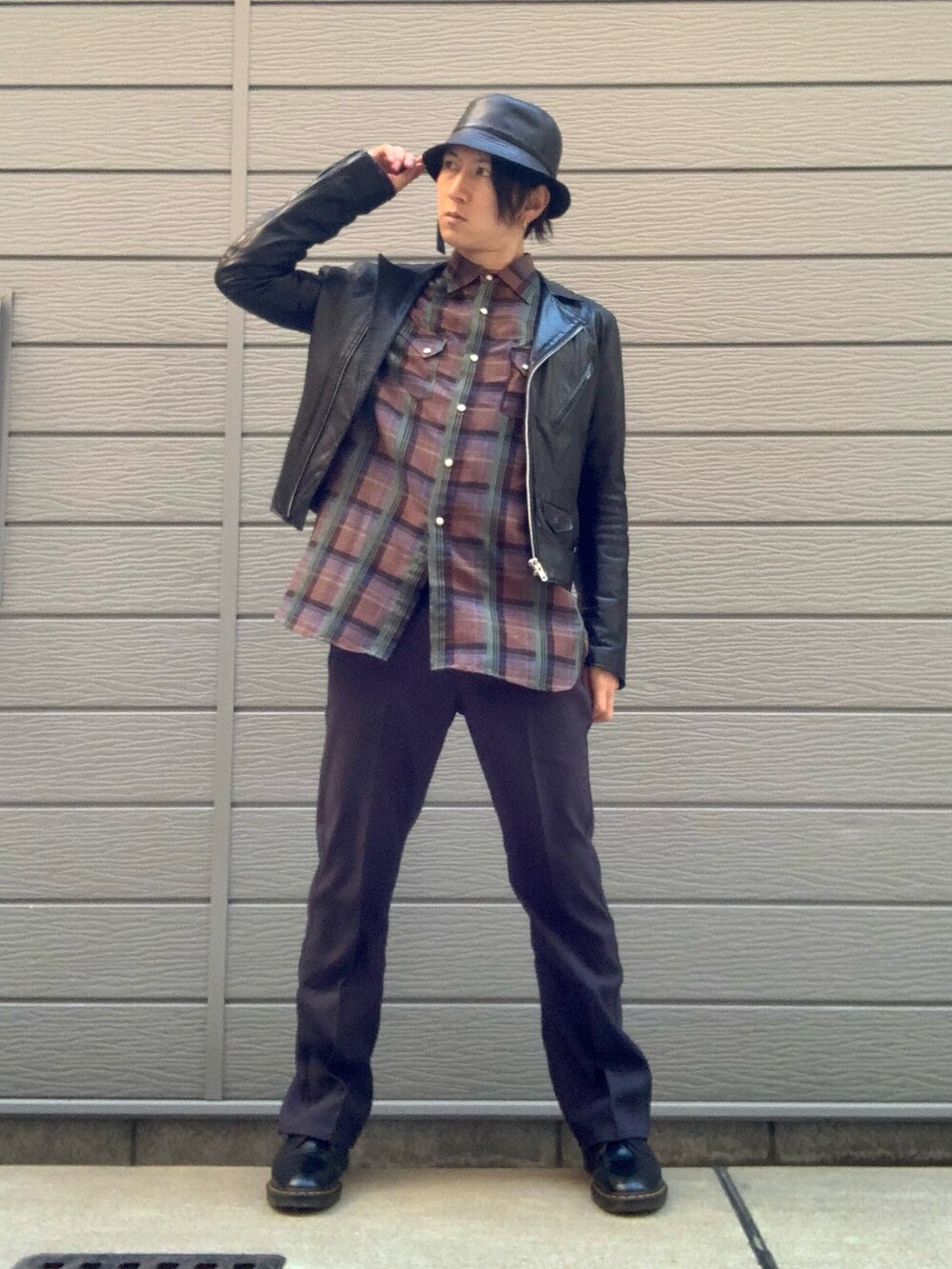 ブラック系のライダースジャケット、グリーン系のシャツ/ブラウス、グレー系のスラックスを着用したメンズの冬コーディネートの2枚目の写真