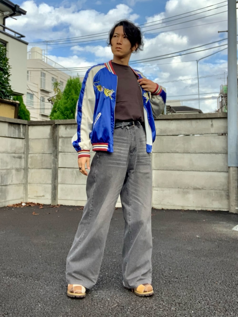 グレー系のデニムパンツ、ブルー系のスカジャン、ブラウン系のTシャツ/カットソーを着用したメンズの秋コーディネートの3枚目の写真