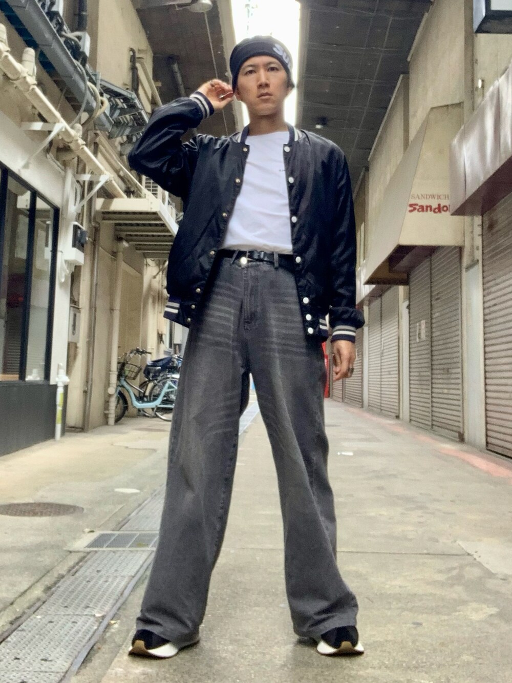 ブラック系のスタジャン、ホワイト系のTシャツ/カットソー、グレー系のデニムパンツを着用したメンズの秋コーディネートの2枚目の写真