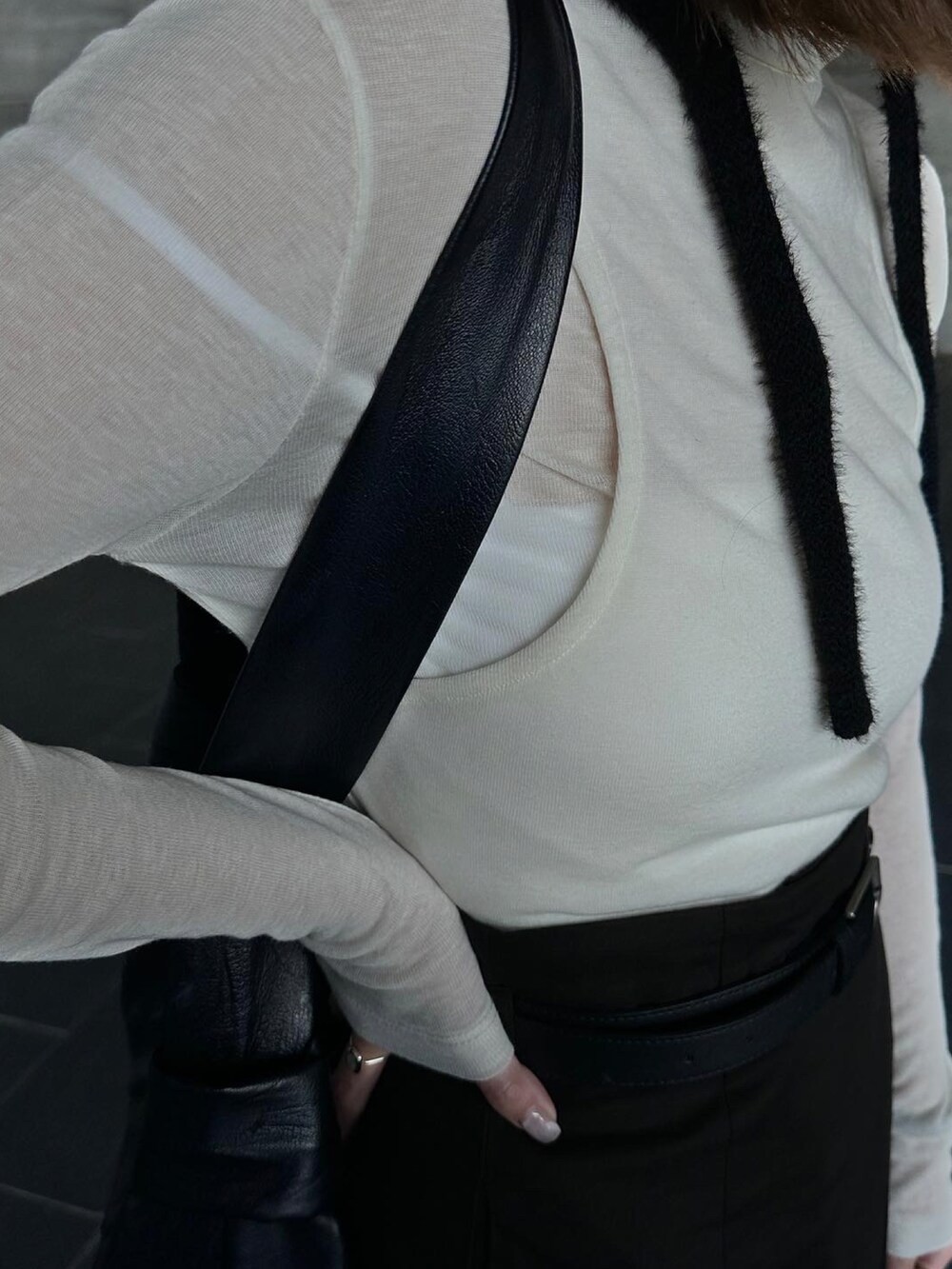 ホワイト系のトップス、ブラック系のスカート、ブラック系のブーツを着用したレディースの春コーディネートの4枚目の写真