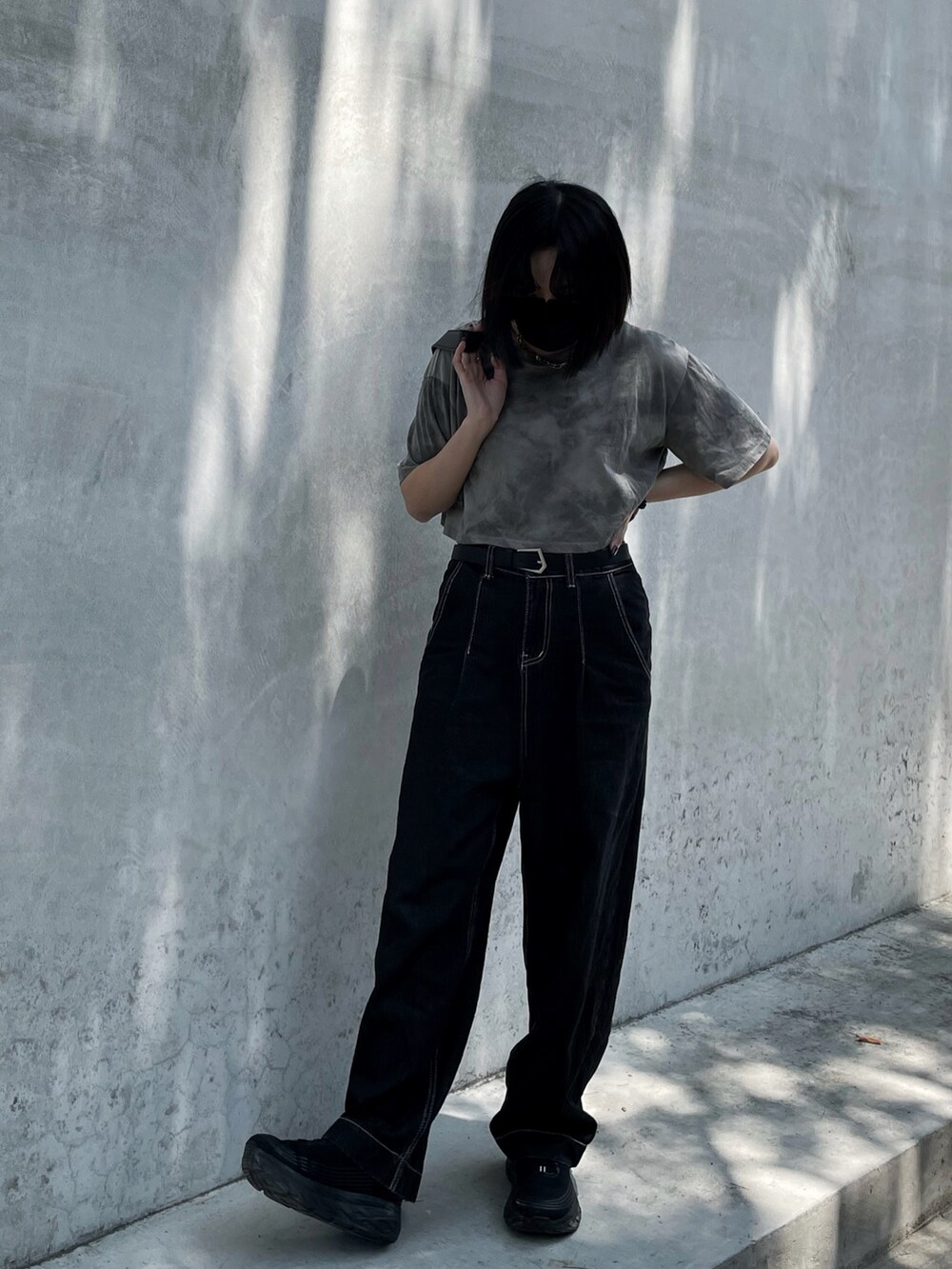 グレー系のTシャツ/カットソー、ブラック系のデニムパンツ、ブラック系のショルダーバッグを着用したレディースの夏コーディネートの2枚目の写真