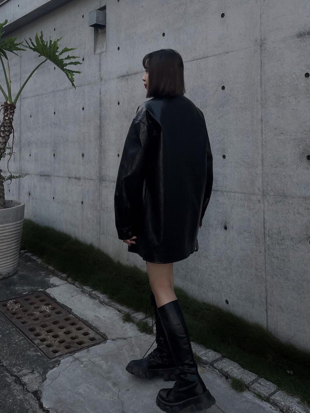 ブラック系のブーツ、ブラック系のジャケット/アウター、グレー系のスカートを着用したレディースの春コーディネートの5枚目の写真