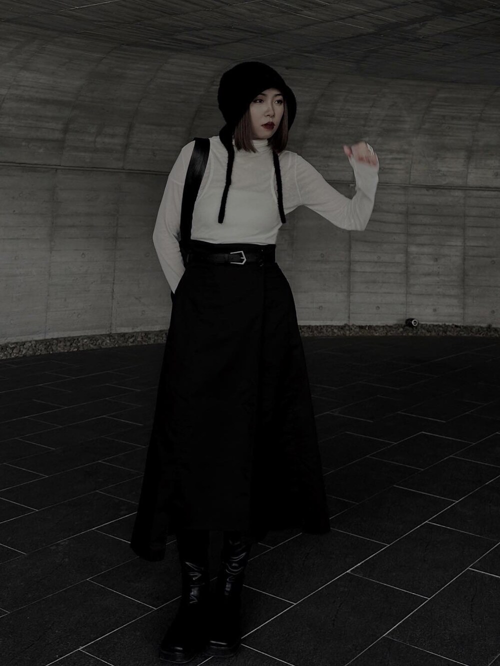 ホワイト系のトップス、ブラック系のスカート、ブラック系のブーツを着用したレディースの春コーディネートの3枚目の写真