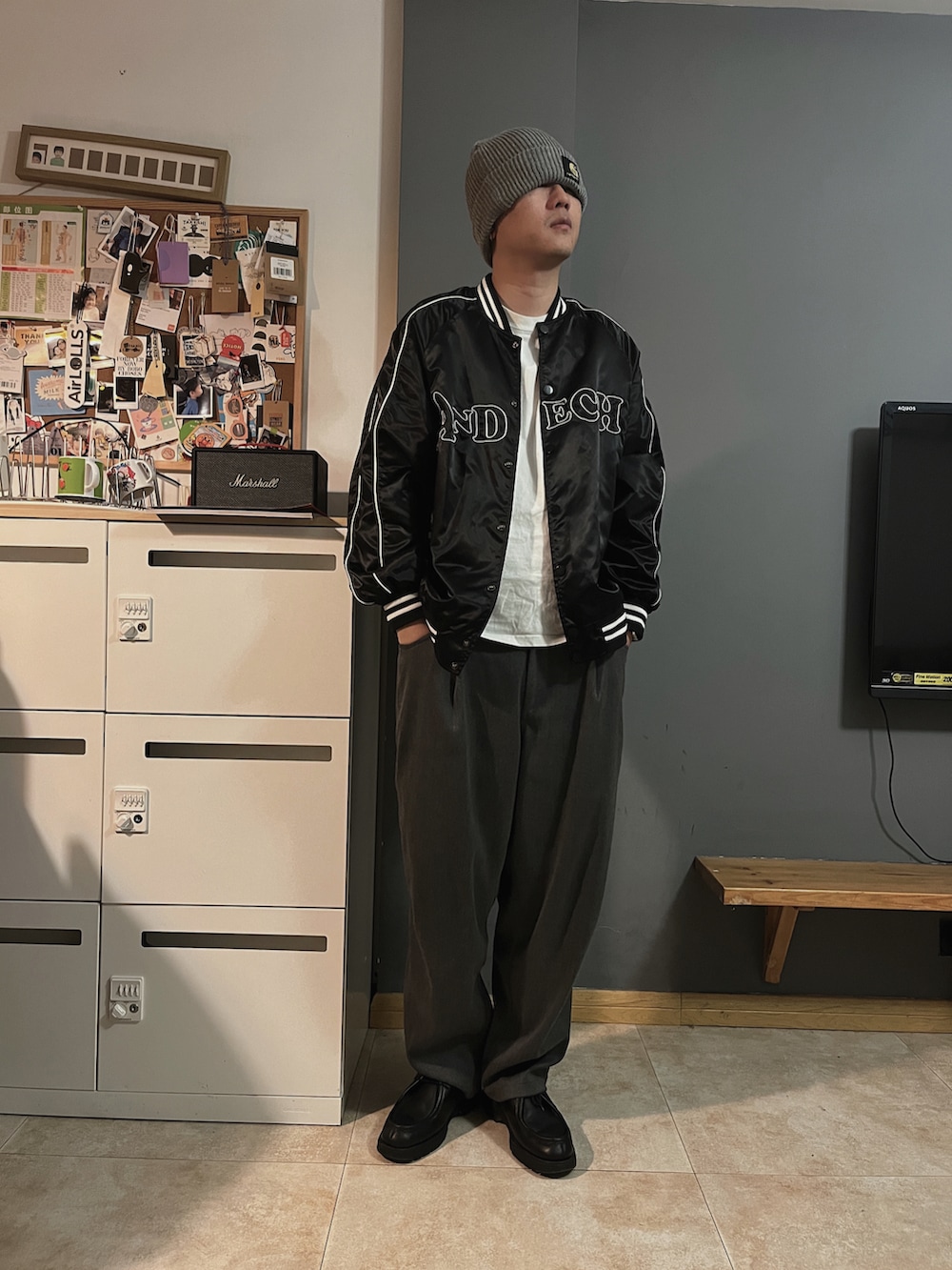 ブラック系のローファー、グレー系のスラックス、グレー系のニットキャップ/ビーニーを着用したメンズの春コーディネートの2枚目の写真