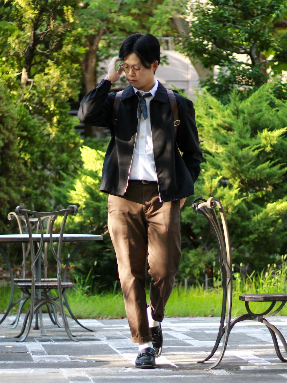 ブラック系のブルゾン、ホワイト系のポロシャツ、ブラウン系のその他パンツを着用したメンズの秋コーディネートの2枚目の写真