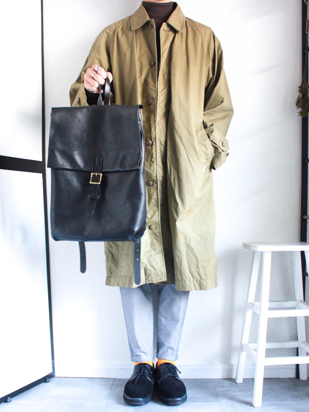 ベージュ系のステンカラーコート、ブラウン系のニット/セーター、ブルー系のその他パンツを着用したメンズの冬コーディネートの2枚目の写真