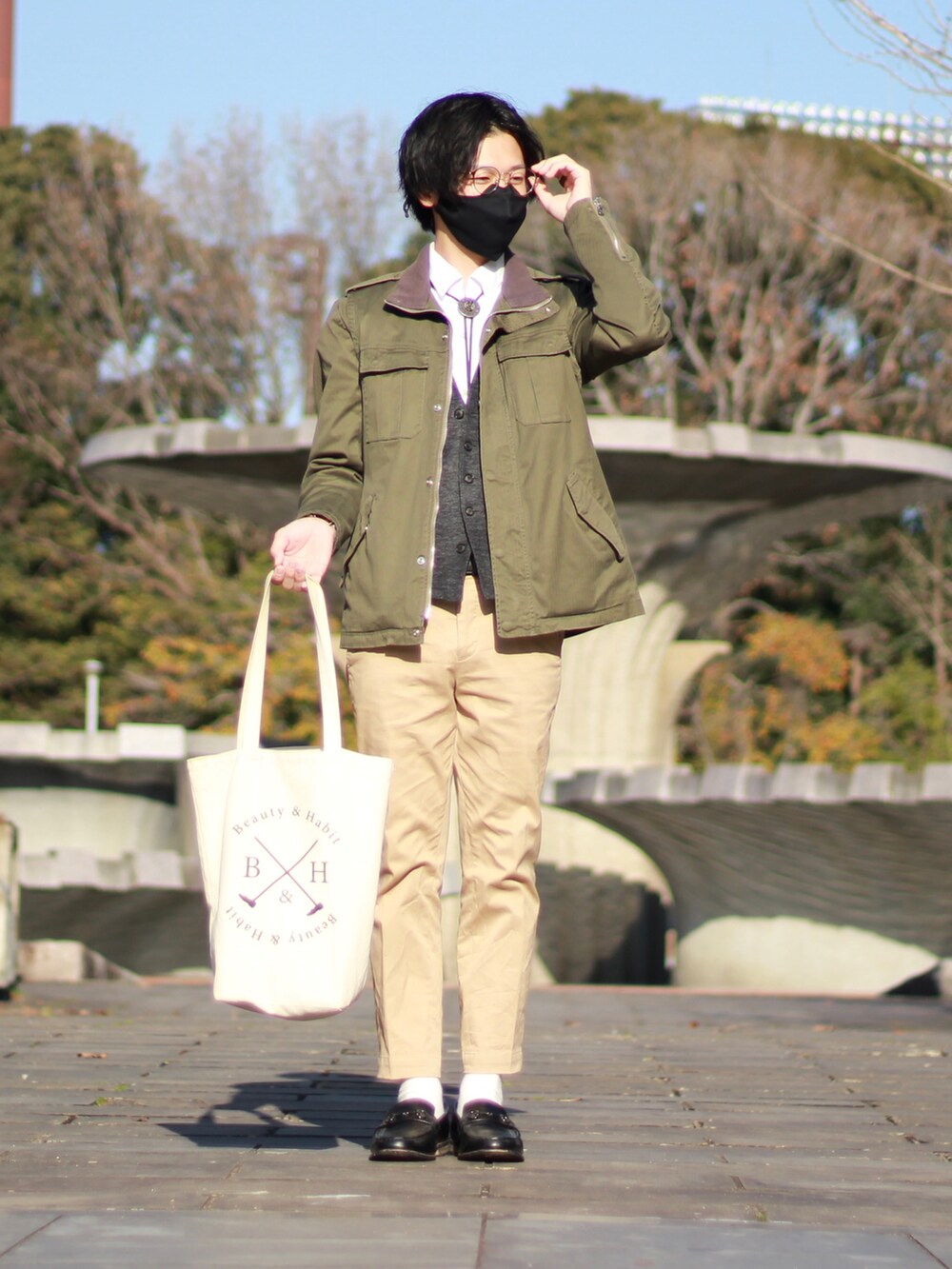 グリーン系のミリタリージャケット、ホワイト系のシャツ/ブラウス、グレー系のベストを着用したメンズの冬コーディネートの2枚目の写真