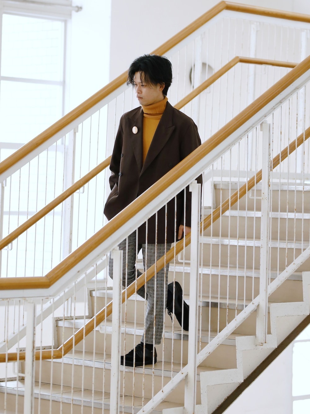 イエロー系のニット/セーター、グレー系のその他パンツ、ブラック系のドレスシューズを着用したメンズの春コーディネートの3枚目の写真