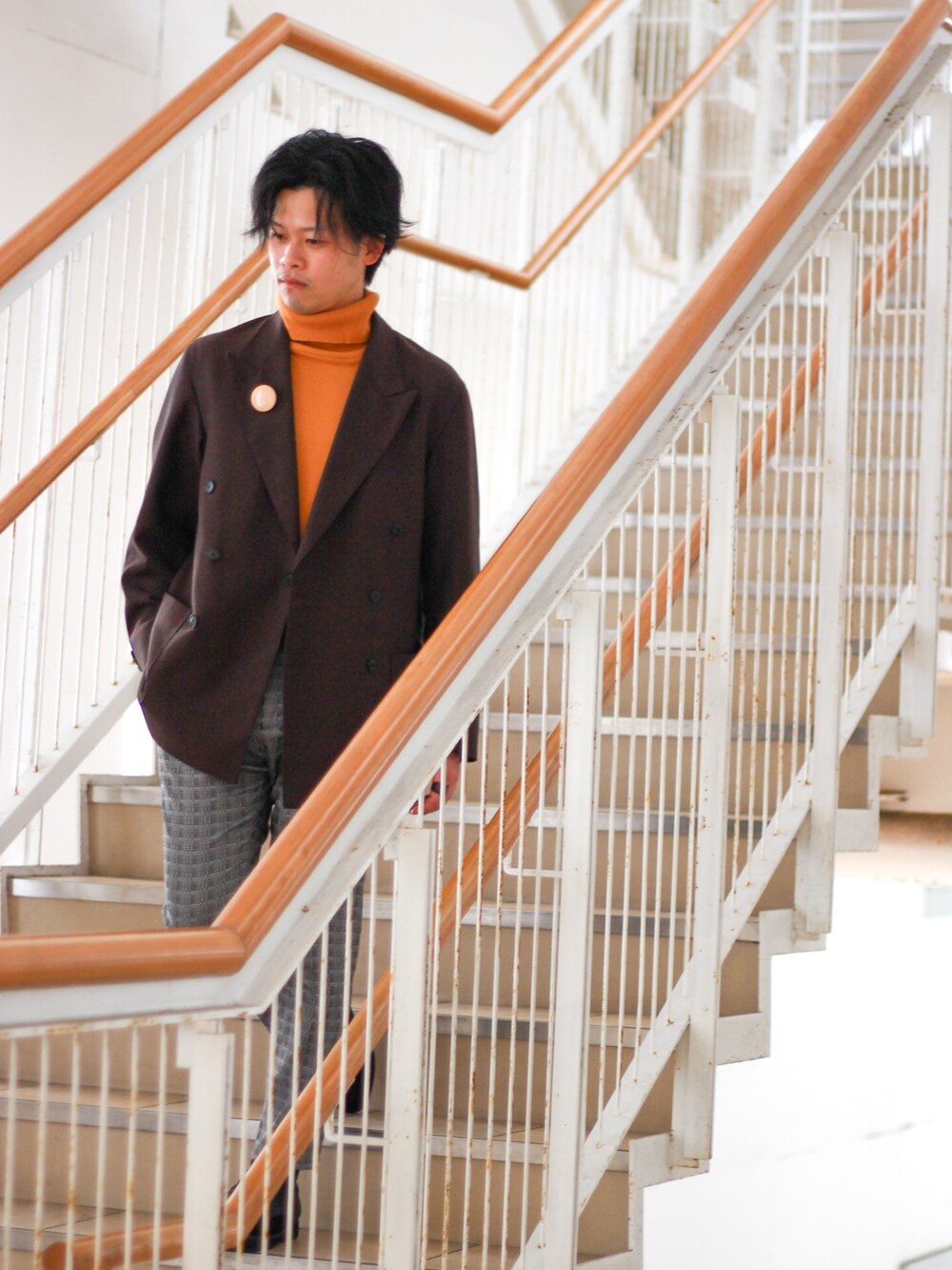 イエロー系のニット/セーター、グレー系のその他パンツ、ブラック系のドレスシューズを着用したメンズの春コーディネートの2枚目の写真