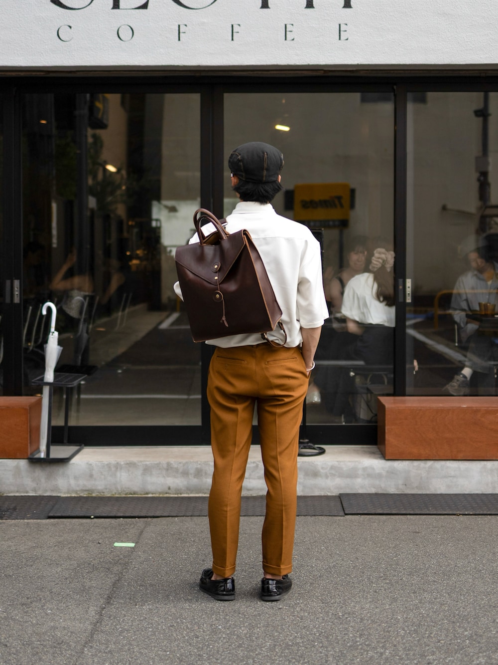 ホワイト系のシャツ/ブラウス、ブラウン系のスラックス、ブラック系のローファーを着用したメンズの夏コーディネートの2枚目の写真