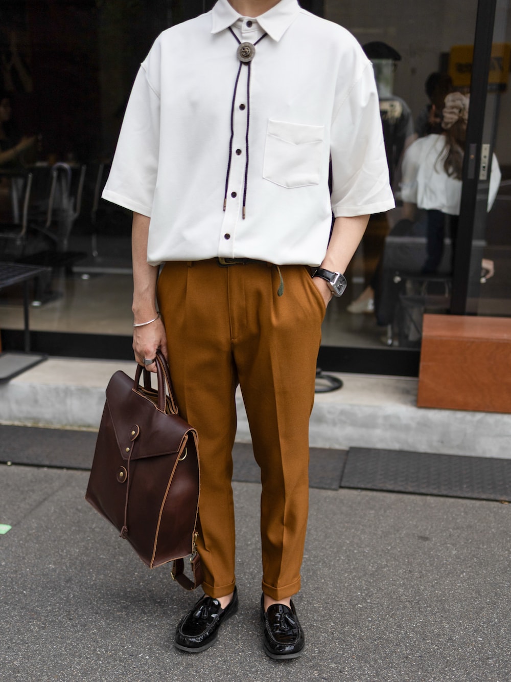 ホワイト系のシャツ/ブラウス、ブラウン系のスラックス、ブラック系のローファーを着用したメンズの夏コーディネートの4枚目の写真