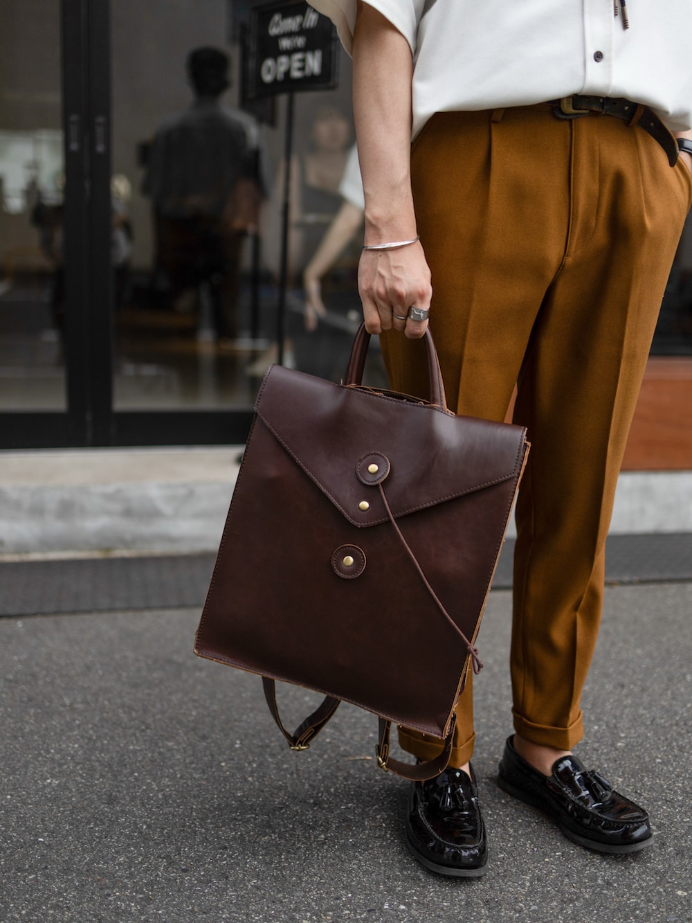 ホワイト系のシャツ/ブラウス、ブラウン系のスラックス、ブラック系のローファーを着用したメンズの夏コーディネートの5枚目の写真