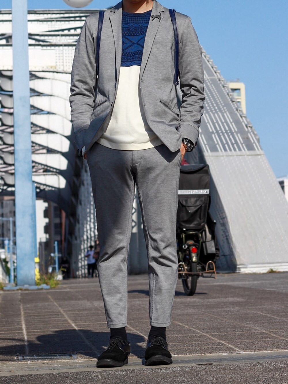 グレー系のテーラードジャケット、ブルー系のニット/セーター、グレー系のその他パンツを着用したメンズの春コーディネートの3枚目の写真