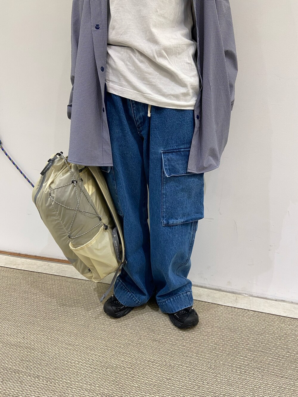 ホワイト系のバックパック/リュック、ブルー系のデニムパンツ、ブラック系のサンダルを着用したレディースの春コーディネートの2枚目の写真