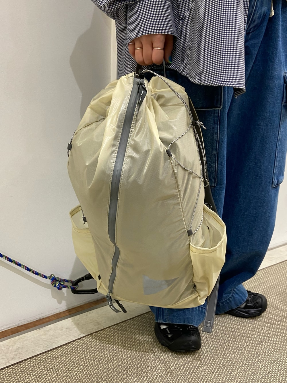 ホワイト系のバックパック/リュック、ブルー系のデニムパンツ、ブラック系のサンダルを着用したレディースの春コーディネートの3枚目の写真