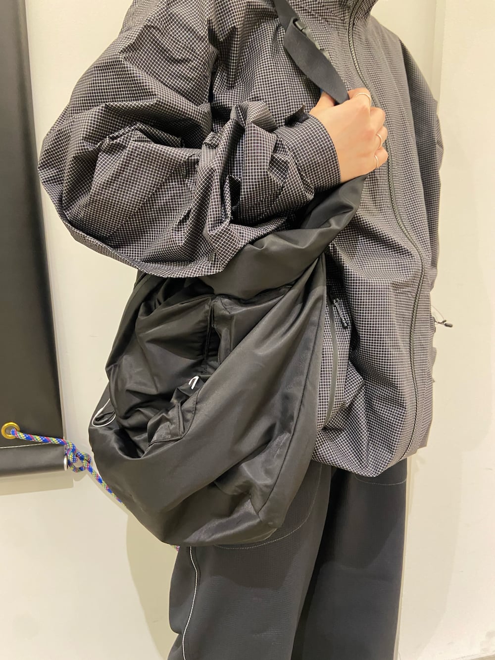 ブラック系のスニーカー、ブラック系のショルダーバッグ、ブラック系のナイロンジャケットを着用したレディースの春コーディネートの3枚目の写真