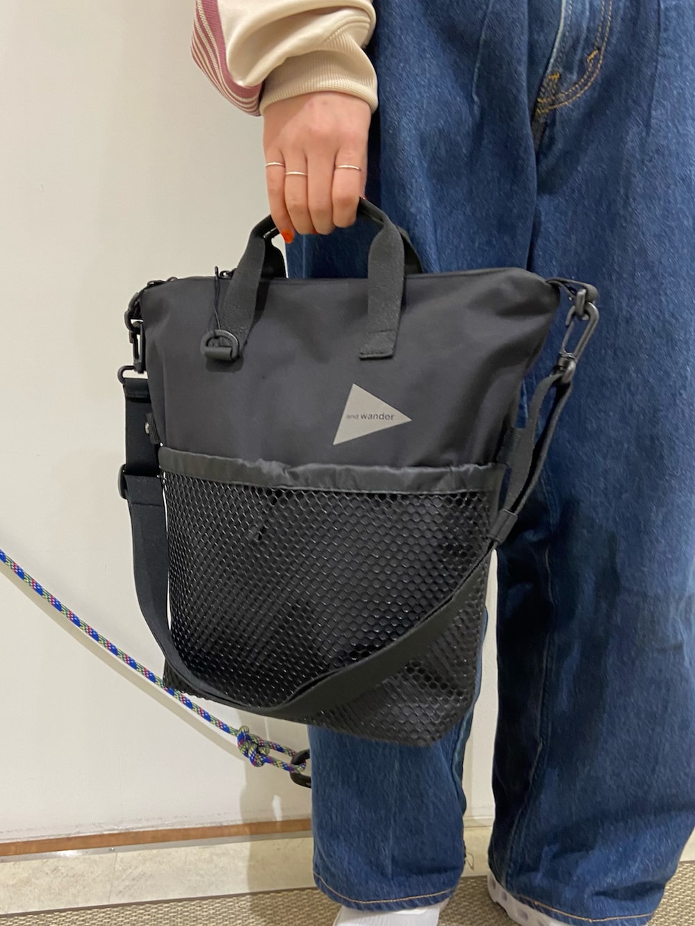 ホワイト系のスニーカー、グレー系のショルダーバッグ、ブラック系のベルトを着用したレディースの冬コーディネートの2枚目の写真