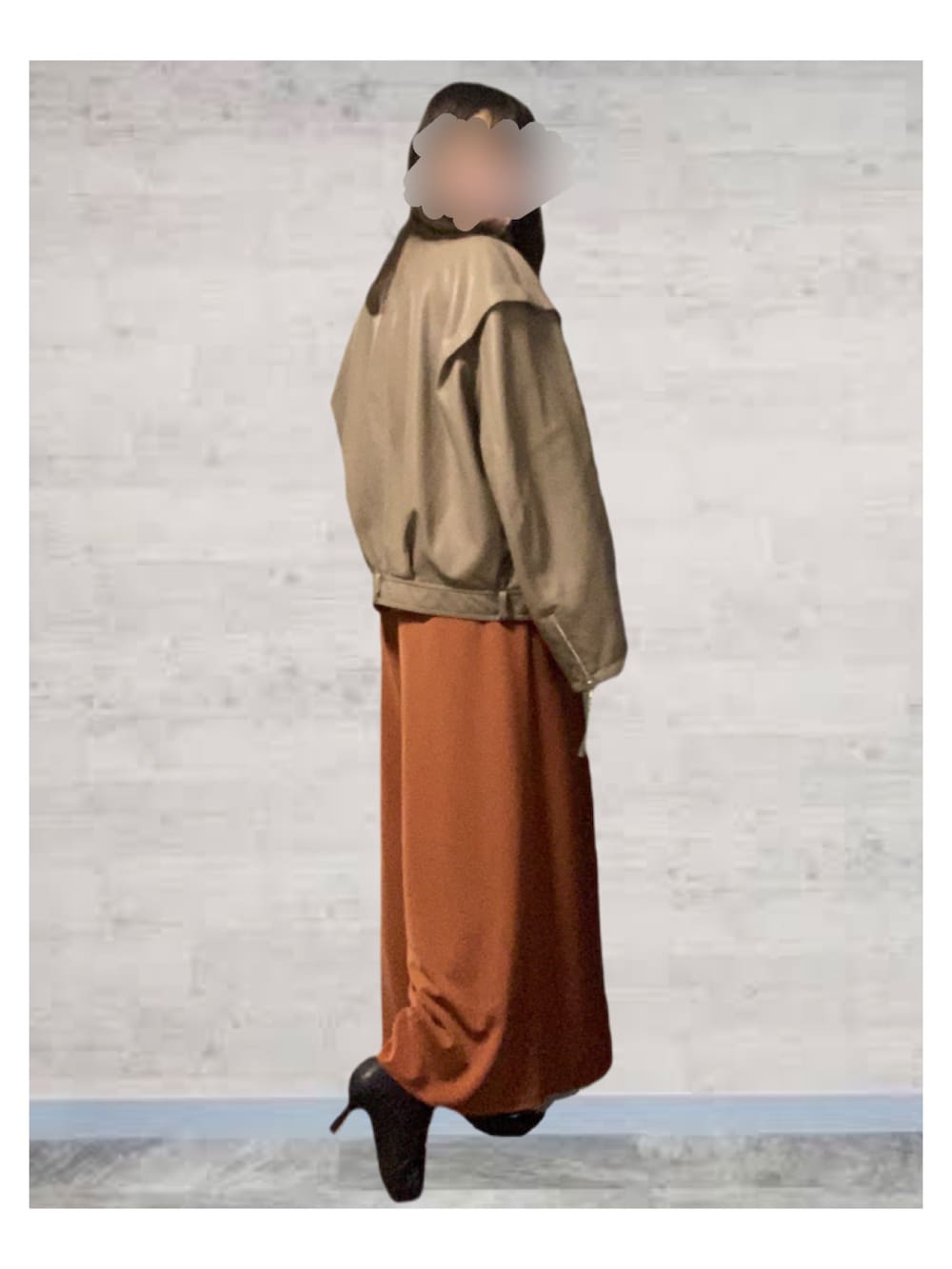 ベージュ系のライダースジャケット、オレンジ系のセットアップ、ブラック系のブーツを着用したレディースの秋コーディネートの2枚目の写真